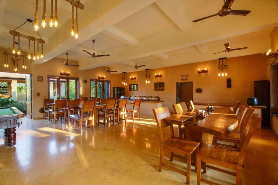 Candlelit dining hall with long teak tables